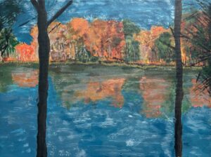 Autumn trees reflecting over a calm lake under a blue sky.