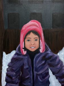 A child in a pink hat and purple jacket sitting in the snow.